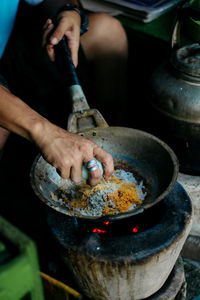 Cropped image of person preparing food on pan