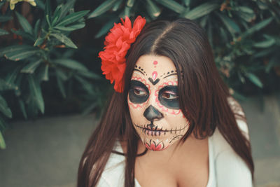 Young face painted female looking at camera during halloween festivity.