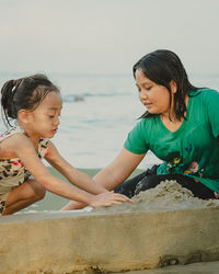 Children playing sand together. asian little kids playing at the beach.