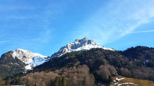 Scenic view of snowcapped mountains against blue sky