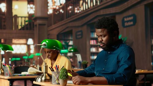 Side view of young man using mobile phone in cafe