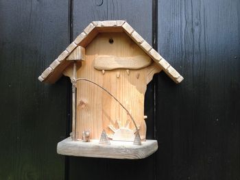 Close-up of birdhouse on wooden table against building