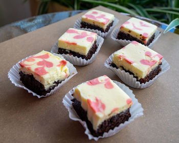 Cream cheese brownies in paper cups and wooden background