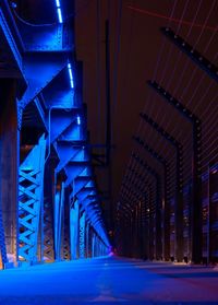 Illuminated bridge amidst buildings in city at night