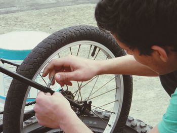 Young man repairing bicycle outdoors