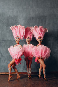 Portrait of women dancing against wall