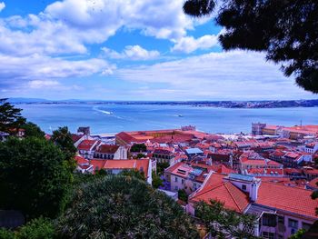 High angle view of townscape by sea against sky