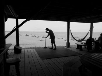 Man cleaning cafe at beach