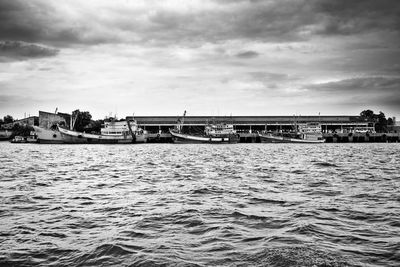 Scenic view of river against sky in city