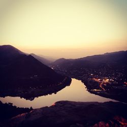 High angle view of river and mountains against sky during sunset