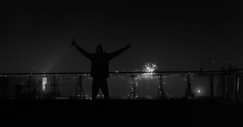 Silhouette of person standing against dark sky