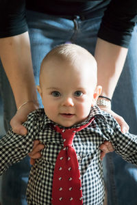 Midsection of mother holding son at home