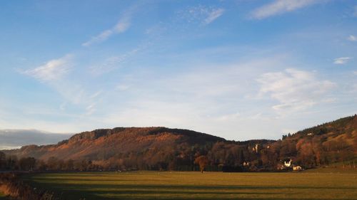 Scenic view of field and mountains against sky