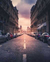 View of city street and buildings at sunset