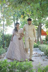 Young couple standing against trees