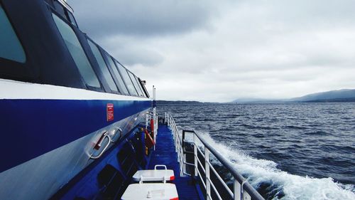 Close-up of ship sailing on sea against sky