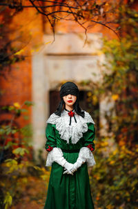 Full length of young woman in halloween costume standing in forest during autumn