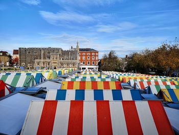 High angle view of multi colored umbrellas by city against sky