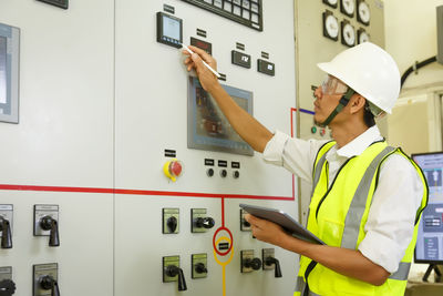 Engineer working on the checking status switchgear electrical energy distribution substation. 