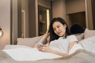 Young woman lying on bed at home