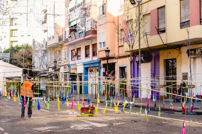 Rear view of people on street against buildings