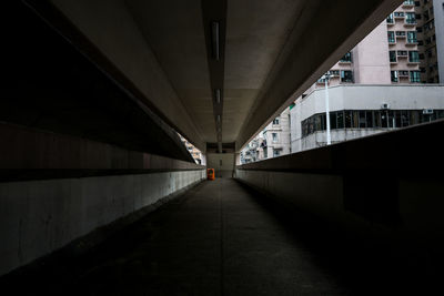 Empty footpath under bridge in city