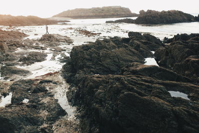 Rock formations by sea against sky