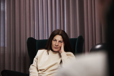 Female patient sitting in armchair at therapy session