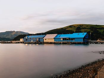 Houses by lake against sky