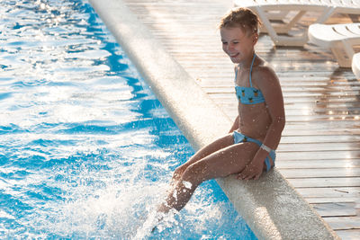 Full length of happy boy in swimming pool