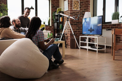 Rear view of woman using laptop at home