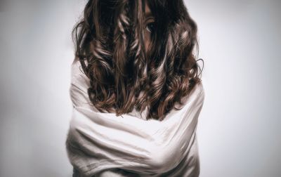 Rear view of senior woman against white background