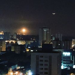 Illuminated cityscape against sky at night