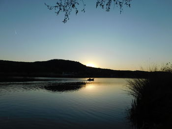 Scenic view of lake against clear sky during sunset