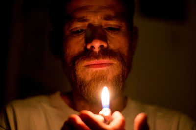 Close-up of man with illuminated cigarette lighter