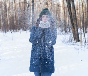 Portrait of woman standing on snow covered land