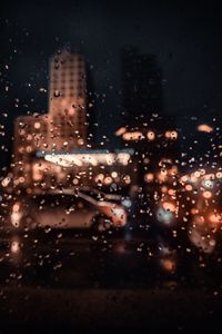 City seen through wet glass window during rainy season