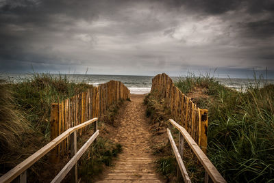 Boardwalk on beach against sky