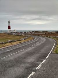 Road leading towards city against sky