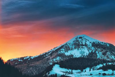 Scenic view of snowcapped mountains against sky during sunset