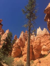 Low angle view of rocks against blue sky