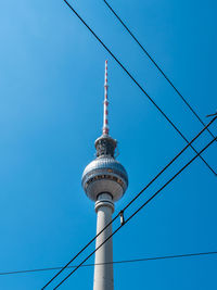 Low angle view of communications tower against blue sky