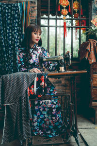 Woman sewing cloth in machine at home