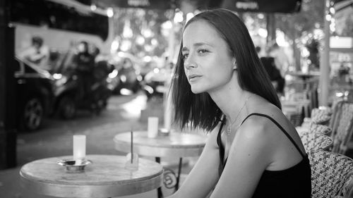 Woman looking away while sitting at cafe