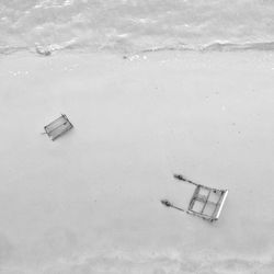 High angle view of damaged shopping carts at beach