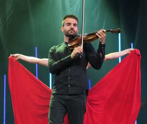 Musician playing violin while standing on stage