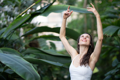 Portrait of young woman exercising on field