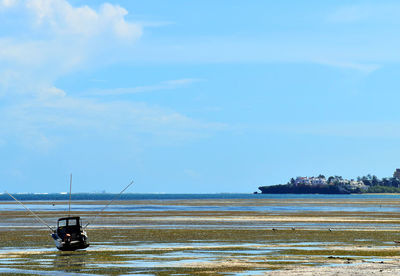 Man sitting on sea against sky