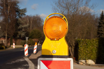 Close-up of yellow road sign on street