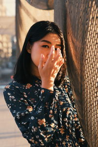Portrait of a beautiful young woman covering face
